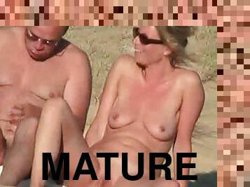 Mature french couple caress each other on a beach and set home