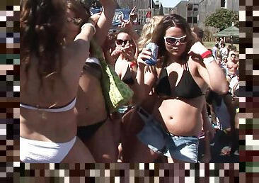 Sensual babes in bikinis and shorts with sexy bodies dancing at an outdoor party