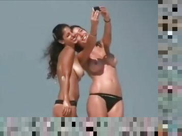 Topless amateur brunette babes get caught on voyeur's cam on a beach