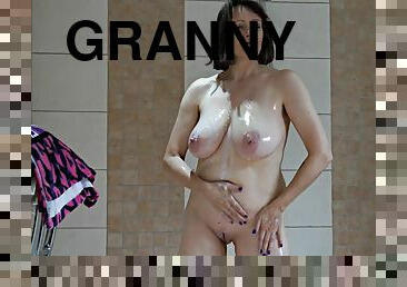 Brunette granny with big tits having fun in the shower