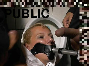 Blonde submissive girl humiliated and gets pee on face in public WC toilette