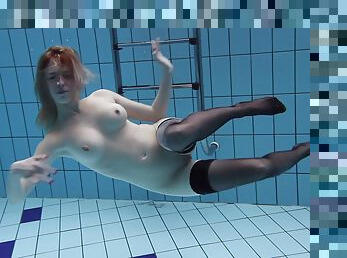 Classy bombshell in stockings likes showing off their tits underwater
